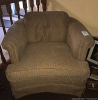 Front view of brown and beige patterned armchair showing rolled arms and seat cushion