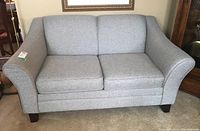 Front angled view of light gray fabric loveseat showing rolled arms and seat cushions