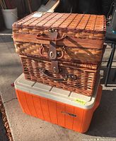 Photo of two picnic baskets stacked on top of an orange Coleman cooler.