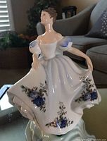Front view of the Royal Doulton Beatrice figurine in white dress with blue floral patterns.