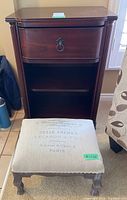 Front view of wood side table and upholstered stool showing drawer detail and print on stool seat.