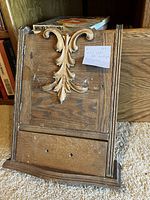 Front view of oak medicine cabinet panel showing heavy carved decoration.