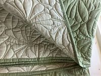 Close-up detail of the quilted floral pattern and fabric texture, showing the neat stitching and finished edges.