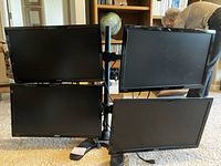 Full view of four 22-inch ASUS monitors mounted on a metal frame in a 2x2 configuration on carpeted floor.
