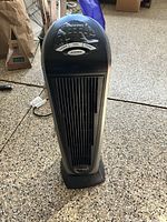Full view of the black and gray Lasko ceramic heater showing front grill and base on floor.