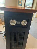 Front control panel of the heater showing two silver knobs and digital temperature display.