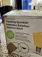 Front of the original box showing the product name, some wear and tape patches, and multilingual product features including self-propelled function.