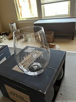 Clear stemless acrylic wine glass displayed on the box.