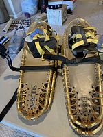 Gold Sherpa snowshoes on table, showing overall condition and design