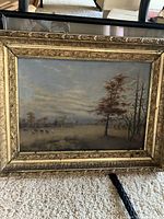 Frontal image of the ornate gilt framed landscape print showing rural scene with trees under a cloudy sky.