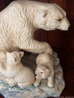 Close-up of the porcelain polar bear family figurine showing detailed texture and facial features.