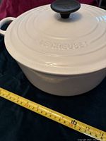Side view of Dutch oven on dark surface with measuring tape showing approximately 30 cm outer diameter.