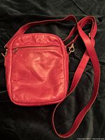 Front view of fuschia padded lambskin pouch with zippered compartment and M0851 logo embossing