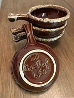 Stacked view of the four onion soup bowls showing the handle and underside marking 'hull Oven Proof USA'.