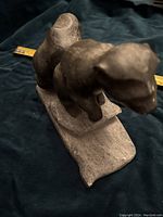 Soapstone skunk carving angled to show side and front profile with a measuring tape nearby.