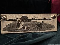 Soapstone rectangular base showing Inuit scene engraving of a person, igloo, and dog with two metal pen holders attached