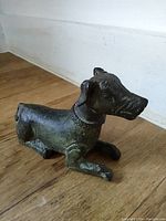Side view of the bronze dog figurine showing head and body details