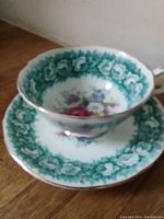 Teacup from above showing interior floral pattern and green border on the saucer
