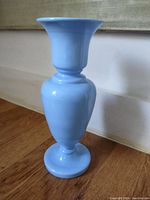 Side view of the hand blown blue glass vase showing its overall shape and glossy blue surface.
