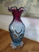 Photo of a handmade glass vase with a purple top fading to blue body and a clear textured base with bubble-like features.