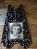 Front view of trench art wooden picture frame holding a black and white woman portrait photo.