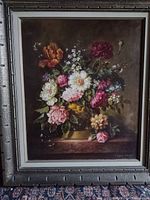 Full view of the framed floral still life oil painting showing a colorful bouquet of flowers on a dark background.
