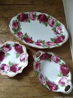 Three pieces of Old English Rose Royal Albert bone china: oval serving dish, scalloped bowl, oval handled tray, all decorated with pink/red roses and gold trim.