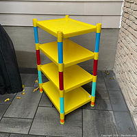 Full view of colourful shelving unit showing yellow shelves and segmented multicolor vertical poles