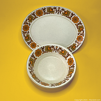 Overhead view of plate and bowl with floral pattern on rims, showing size and pattern details.
