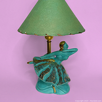 Front view of the lamp showing ballerina figurine and green fabric lamp shade