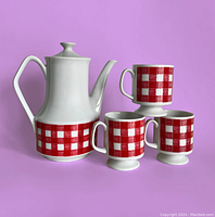 Photo of vintage white porcelain tea pot with red and white checkered band and three matching mugs, all in excellent condition