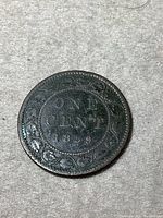 Reverse side of the coin showing denomination ONE CENT and the year 1859 with decorative wreath.