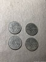 Four Canadian 5 cents coins from 1931, 1932, 1933 and 1934 displayed together on gray felt background.