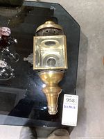 Side view showing brass front and glass panes of vintage carriage lantern.
