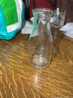 Full view of the clear glass bottle showing the overall shape and size with wide mouth and thick rim.