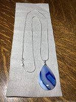 Full view of the sterling silver chain laid out with the pendant showing the entire length and design.