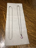 Two sterling silver chains approximately 16 inches in length, one with a pink star-shaped pendant.