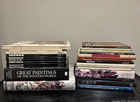 Photo of two stacks of hardcover art books showing spine titles and cover art.