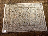 Full view of rug on parquet floor with label visible