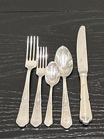 Sample of one dinner fork, salad fork, tablespoon, teaspoon and dinner knife showing handle pattern and finish
