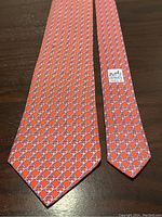 Orange Hermes silk tie laid flat showing full length and link pattern