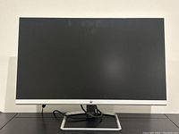 Front view of HP monitor powered off showing screen and stand