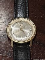 Front view of Birks Eterna-Matic watch face showing dial, date window, and leather strap