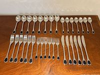 Overview of complete set arranged in rows showing all spoons, forks, and knives