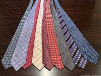 Overhead view of nine ties laid side by side showing full set and color patterns