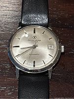 Front-facing close-up of dial showing brand logo, “Automatic” text and date window at 3 o’clock