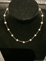 Front view of the necklace draped on a black velvet bust