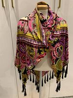 Shawl displayed on dress form showing overall size, shape, and tassels.