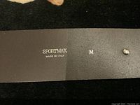 Close-up photo showing the SPORTMAX logo stamped on the inside of the leather belt, along with size M and Made in Italy marking.