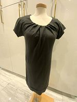 Full front view of the black vintage Diane Von Furstenberg dress on a mannequin, showing short sleeves and overall condition.